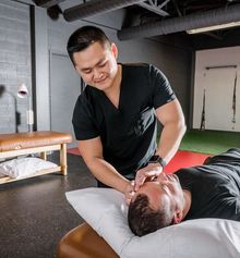 Acupuncturist Langhin Lai giving a treatment to a patient at Junxion Performance's clinic