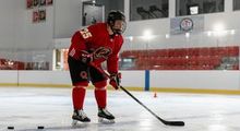 A hockey player waiting to accept a pass in a full red Hockey Etcetera uniform