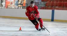 Hockey player doing a sharp turn around a pylon