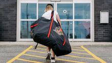 Un joueur de hockey junior arrive avec son sac devant Hockey Etcetera