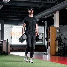 Tanner Kichler lifting 2 x 100lbs weights inside Junxion Performance gym