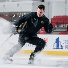 A group of Hockey Etcetera trainers smiling on the ice