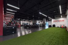 Wide view of the Junxion Performance gym with the turf in the foreground and the weight section in the background