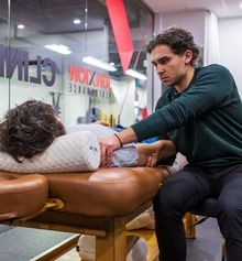 Justin Shoif examining a client's shoulder in the Junxion Performance clinic