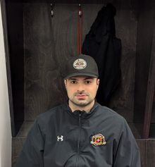 Daniel Portelance coaching and pointing his stick to instruct a player