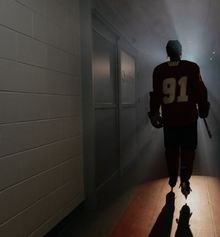 Un jeune joueur de hockey qui marche vers la patinoire dans un éclairage dramatique