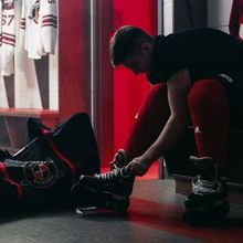 Tape and water bottles sitting on the dressing room table at Hockey Etcetera with jerseys hanging in the stalls in the background