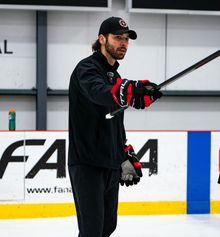 Daniel Portelance coaching and pointing his stick to instruct a player