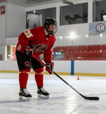 A hockey player waiting to accept a pass in a full red Hockey Etcetera uniform