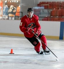 Hockey player doing a sharp turn around a pylon