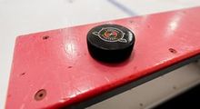 Hockey Etcetera puck sitting on the boards