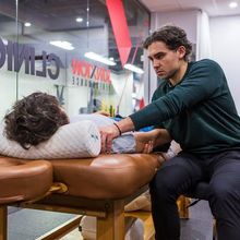 Justin Shoif examining a client's shoulder in the Junxion Performance clinic