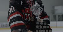 A close up photo of a goalie holding the trophy at the Hockey Etcetera Coast to Coast showdown in 2023