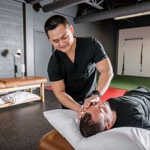 Acupuncturist Langhin Lai giving a treatment to a patient at Junxion Performance's clinic